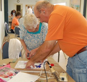 Instructor working with student in stained glass