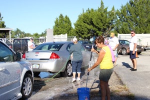 Some of the dedicated volunteers hard at work getting the grime off cars.